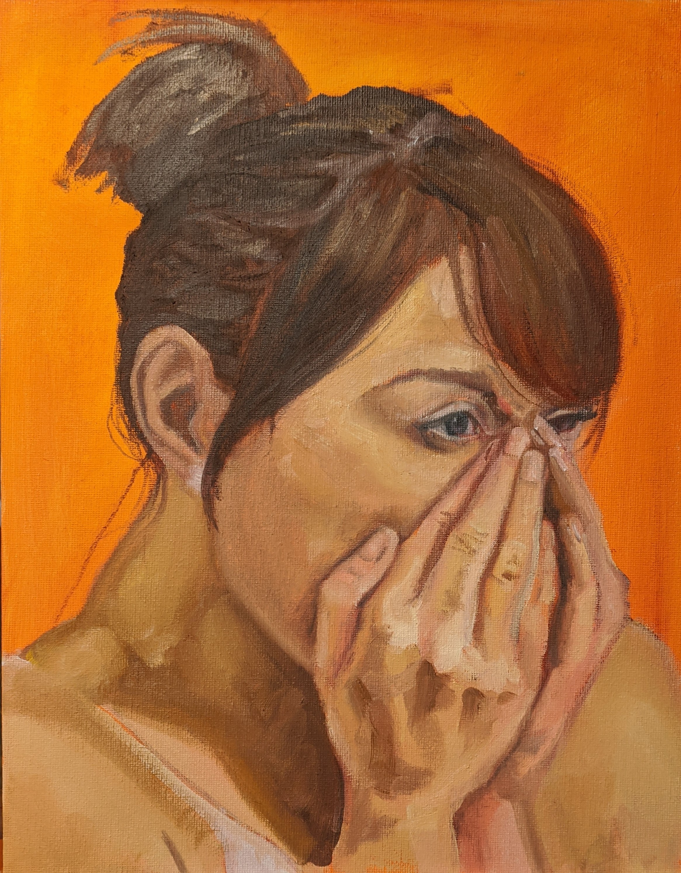 Three-quarter view of a woman's face with her hands up covering her nose and mouth in surprise or shock. Against an orange background.